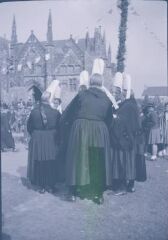 1 vue  - Le Folgoët. - Fête Notre dame du Folgoët, basilique (arrière plan), calvaire (second plan), femmes en costume (premier plan) (ouvre la visionneuse)